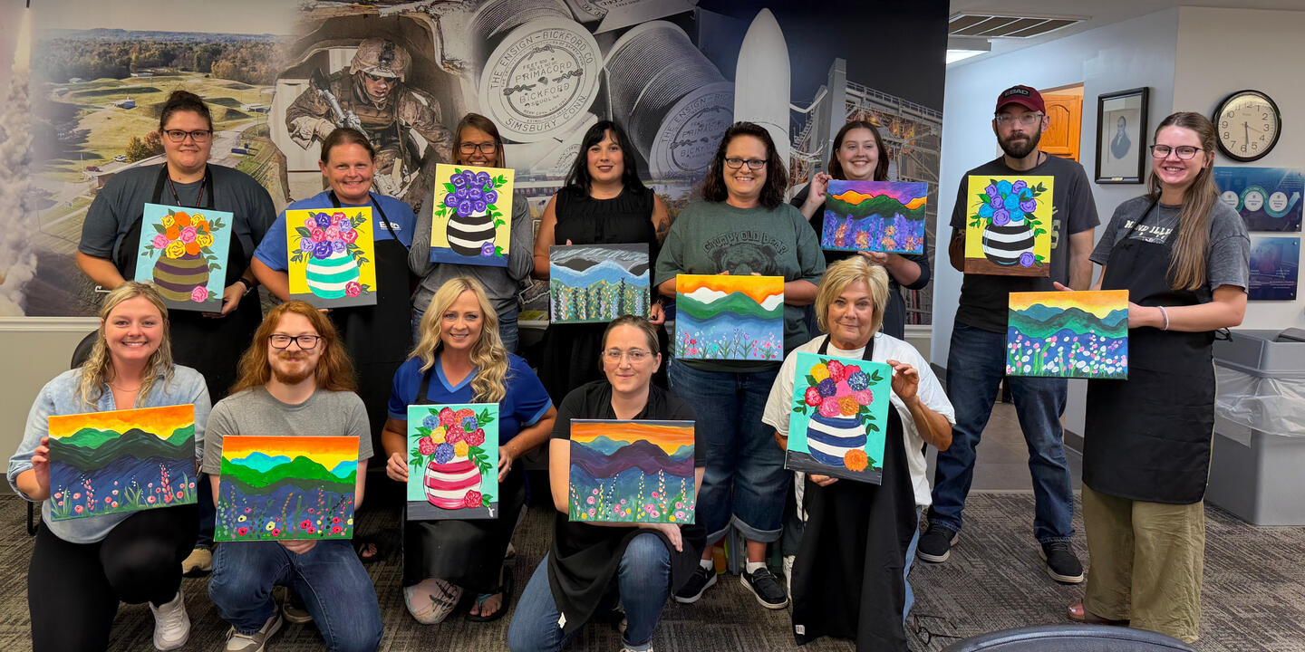 Workplace Team Building Paint Party in Graham KY | Art & Aperture Employees showing their finished canvas paintings after an Art & Aperture workplace paint party and team-building event in Graham, Kentucky.